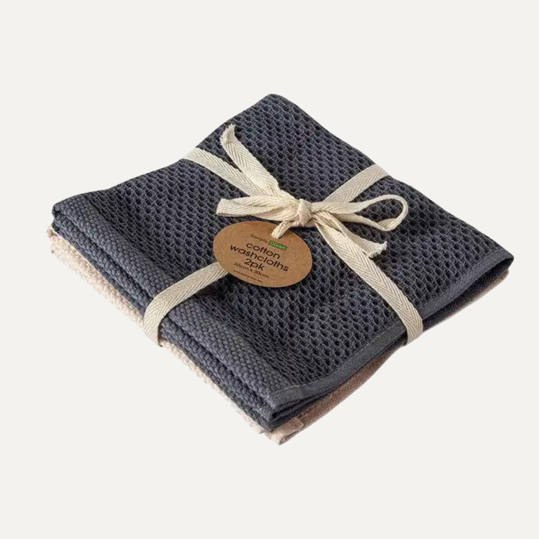 Set of two dark gray waffle towels tied with a beige ribbon on a white background. Simply Clean Cotton Wash Cloth - 2 Pack