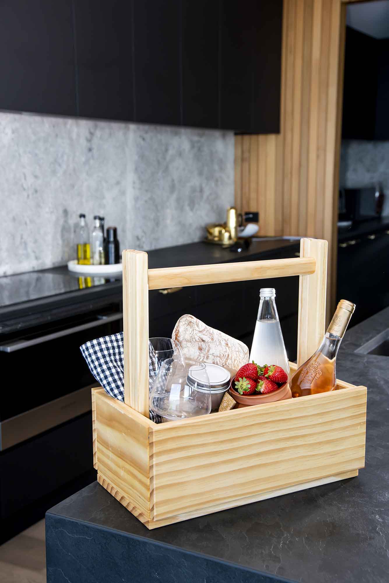 Wooden picnic basket with food and drinks on a kitchen counter. Victoria James Home Storage Box VJA Convertible